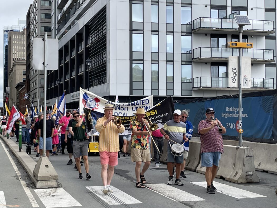Parade of people walking down street.